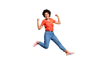 Full length photo of crazy ecstatic girl raise her fists scream shout yeah celebrate victory lottery discounts jump wear red t-shirt trendy denim jeans sneakers isolated over yellow color background