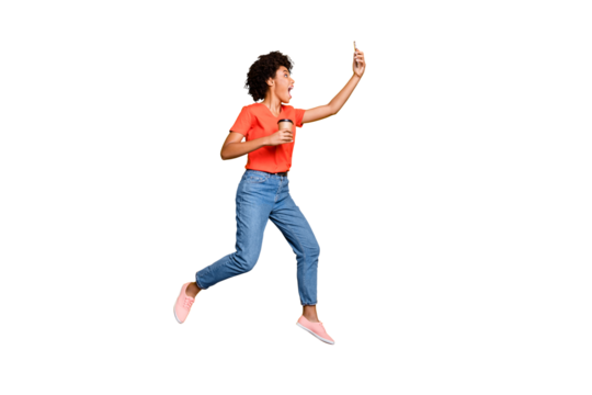 Full body profile side photo of crazy funny wavy hair beautiful girl use cellphone take selfie trip journey hold mug jump wear t-shirt jeans sneakers isolated over yellow color background