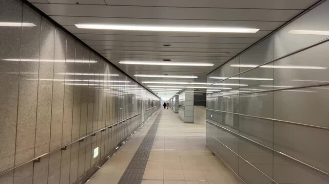 白い蛍光灯が続く新宿駅の長い地下通路