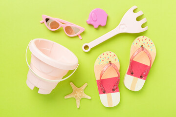 Children's flip flops and beach toys on color background,,top view