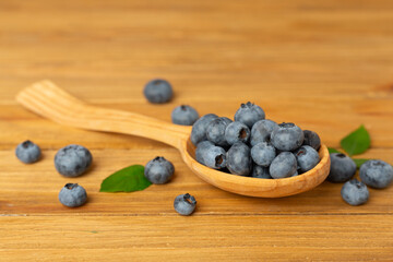 Bowl with fresh blueberries on wooden table