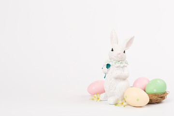 Easter bunny with painted eggs on color background