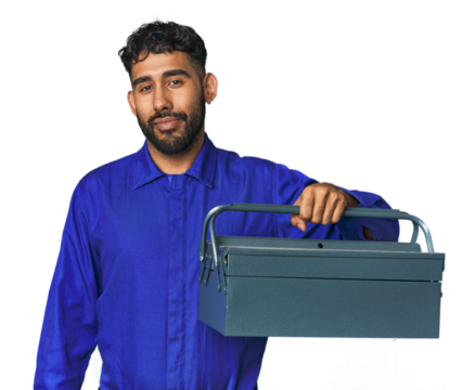 Young Hispanic male mechanic holding a toolbox in studio