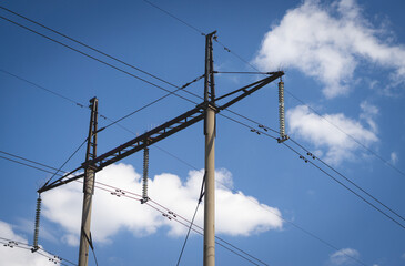 Poles with high voltage wires against the blue sky