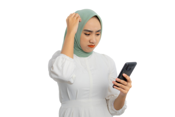 Confused young Asian woman in green hijab and white blouse looking at mobile phone screen while expressing frustration isolated on transparent background