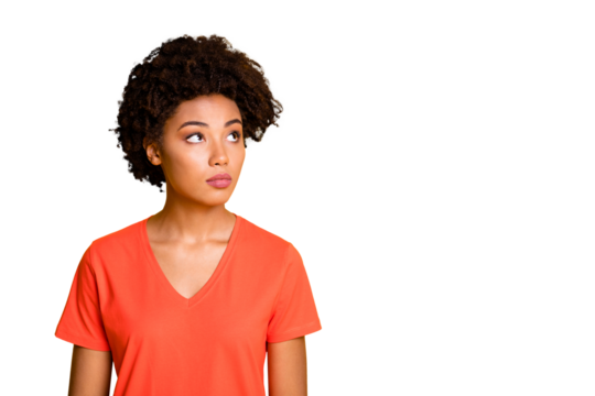 Photo of pretty dark skin lady looking empty space without smiling wear orange v neck t-shirt isolated yellow color background
