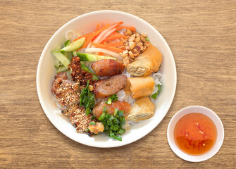 Bun thit nuong. A bowl of Vermicelli Noodles with Grilled Pork and Egg Rolls, Vietnamese grilled pork and rice noodles. Fried Spring Rolls Cold Rice Vermicelli with sauce served in bowl isolated.	