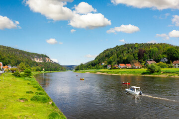 Fototapeta premium Panoramic scenic view rental boat cruising Elbe river curve Sachsische Schweiz National Park Germany Koenigstein Whelen mountain valley blue sky sunny day. Europe travel nature landscape destination