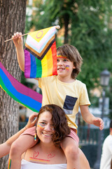 Mother and child celebrating with intersex-inclusive progress pride flag at pride parade