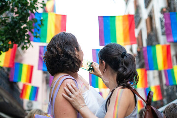 Obraz premium Women taking photos at gay pride parade celebrating lgbtq+ rights