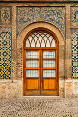 Iranian tile design, wooden door, Old wooden door with colorful tiles, Persian architecture with tile and wood, Historic door framed with tiles, Colorful wall with vintage wooden door