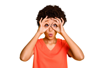 Photo of charming nice cute attractive girlfriend fooling pretending to wear glasses with fingers round her eyes wearing orange t-shirt isolated over yellow vibrant color background