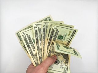 Male white left hand holding a bunch of dollars on a white background in the center of the image...