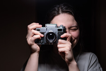 Girl holding a camera on a black background