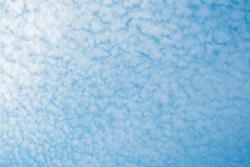 Cloudy sky with a soft blue background during midday