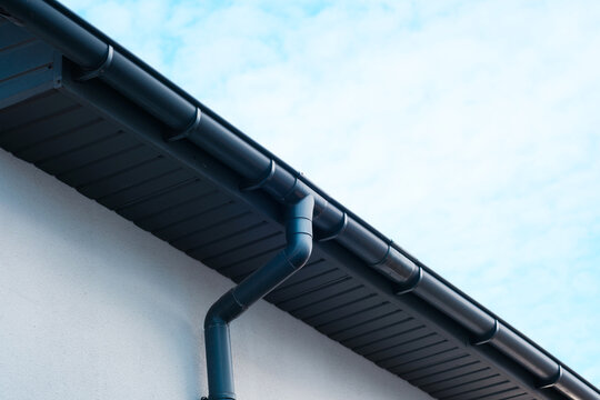 Roof guttering system installed on a residential building under a clear sky