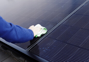 hand with rags cleans the imprints on the solar panels