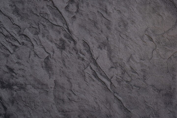 Textured dark stone surface with natural patterns and grooves