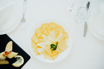 Delicious array of cheeses served on a white plate at a dining table