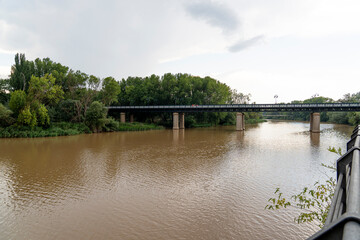 Iron Bridge over Ebro River in Logro&ntilde;o, La Rioja with Lush Vegetation