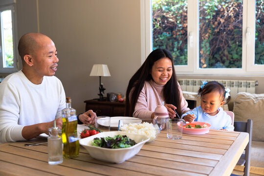 Parents and toddler sharing a family meal at home