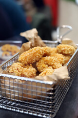 calamares fritos rebozados en una cesta de aluminio de una freidura