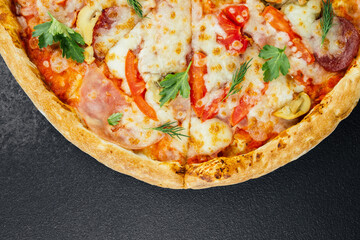 Delicious pizza topped with fresh ingredients served on a black surface