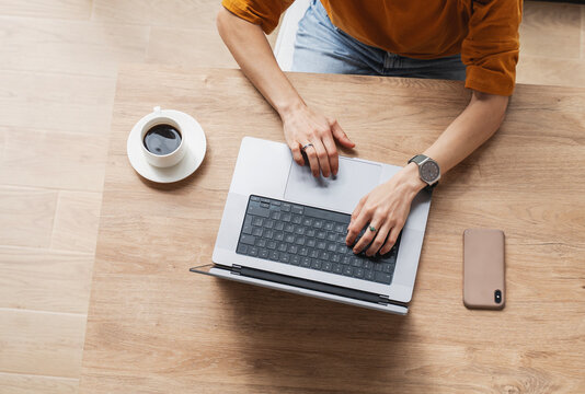 Working home concept Woman using a laptop computer for work at home top view.