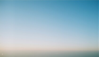 Obraz premium Clear Blue Sky at Sunset: A serene and calming image of a boundless blue sky as the sun sets on the horizon, creating a breathtaking gradient of colors. 