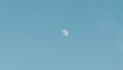 Crescent Moon in Azure Sky: A delicate crescent moon hangs serenely against a vast expanse of azure sky, offering a glimpse of celestial beauty and quiet serenity.