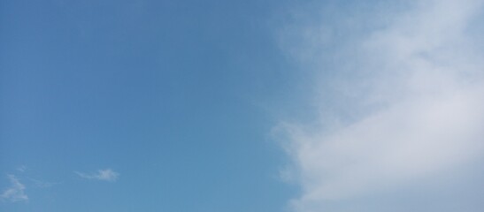 Obraz premium Serene Sky with Scattered Clouds. Blue Sky and Soft Cloudscape. Tranquil Sky with Light Clouds Background.