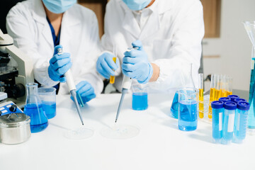 Fototapeta premium Two scientists in a high-tech lab analyzing biochemical samples, using micro pipettes