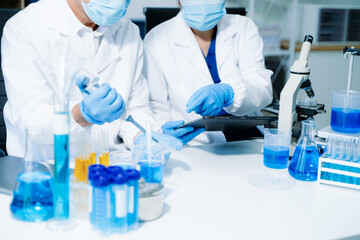 Fototapeta premium scientists in lab coats conducting research, handling glassware, and working with chemicals