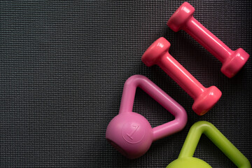 close up dumbbell and kettlebell on a yoga mat background, flat lay sport concept