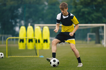 Young Boy in Football Team Focused On Training Drill. Soccer Academy Player in Training on Practice...