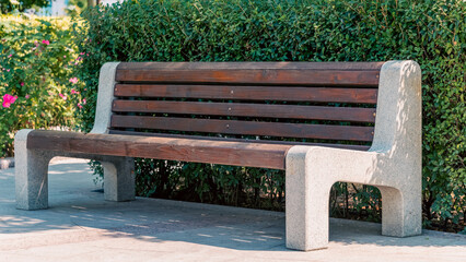 wooden bench and green trees in a city park without people