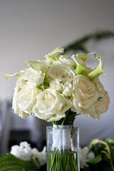 Beautiful wedding bouquet of white roses and calla in a glass vase
