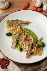 Gourmet Artisanal Linguine Pasta With Razor Clams
Aglio & Olio Sauce, Broccolini, Roasted Aromatic Breadcrumbs - fine dining Italian Seafood dish presentation. 
