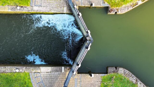 Canal lock adjusting water levels between sections. Sluice gate releasing controlled water flow. Hydraulic system managing navigation passage. Waterway lock regulating current transition