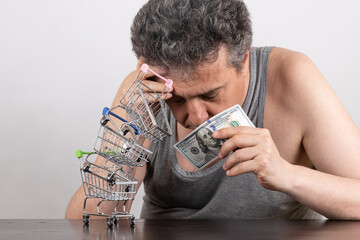 Conceptual story about poverty with a grey-haired middle-aged man, 100 US dollars bill and...