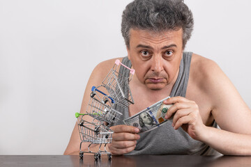 Conceptual story about poverty with a grey-haired middle-aged man, 100 US dollars bill and...