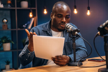 Reading from paper. Man is doing podcast in the studio