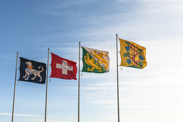 Flags fluttering in the wind against a blue sky background (from left to right: Ermatingen municipal flag, Swiss flag, Canton of Thurgau, Triboltingen municipal flag), Canton of Thurgau, Switzerland