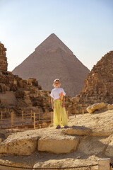 Child exploring ancient ruins near the Great Pyramid of Giza during golden hour