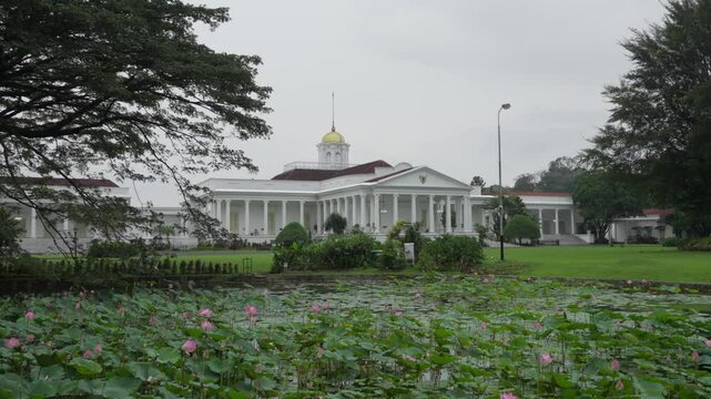 A grand view of the Indonesian Presidential Palace in Bogor, with a lotus-filled pond