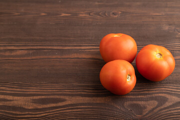 Red tomato on brown wooden, Side view, copy space