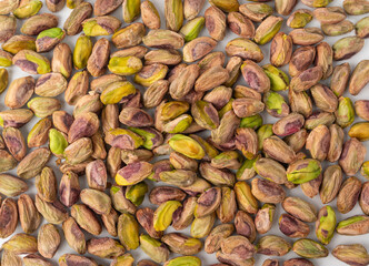 Fried salt pistachio nuts texture background. Baked pistachios grains pattern, pistache fruits