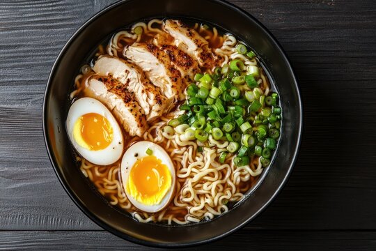 Bowl of ramen noodles with chicken eggs and green onions on dark surface. - Powered by Adobe