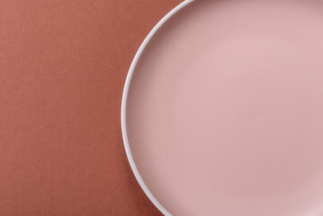Empty ceramic plate on a monochrome brown background