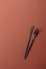 Knife and fork, cutlery on a brown dining table